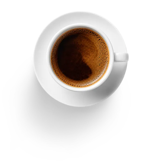A coffee cup beside a laptop during a quiet morning