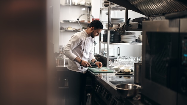 Kitchen staff preparing orders at a stainless-steel prep line